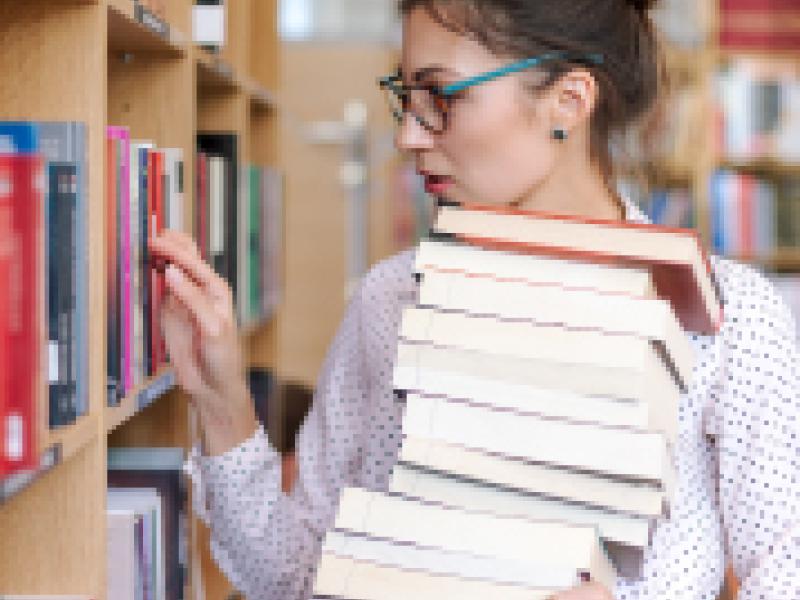 A customer holding a stack of books.